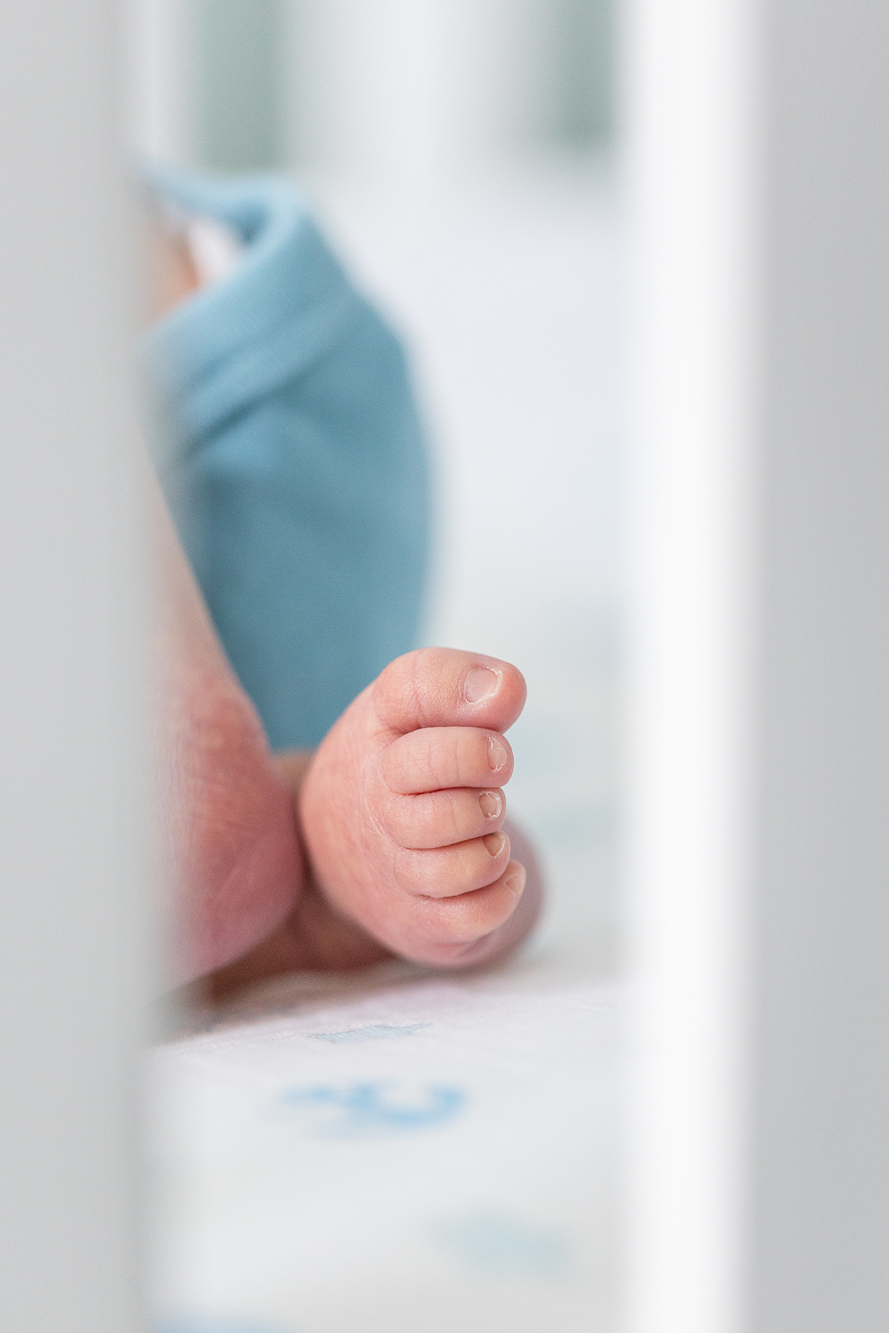 Norfolk Newborn Photographer, Newborn feet, newborn lifestyle photographer, baby in crib, baby's feet laying down in crib