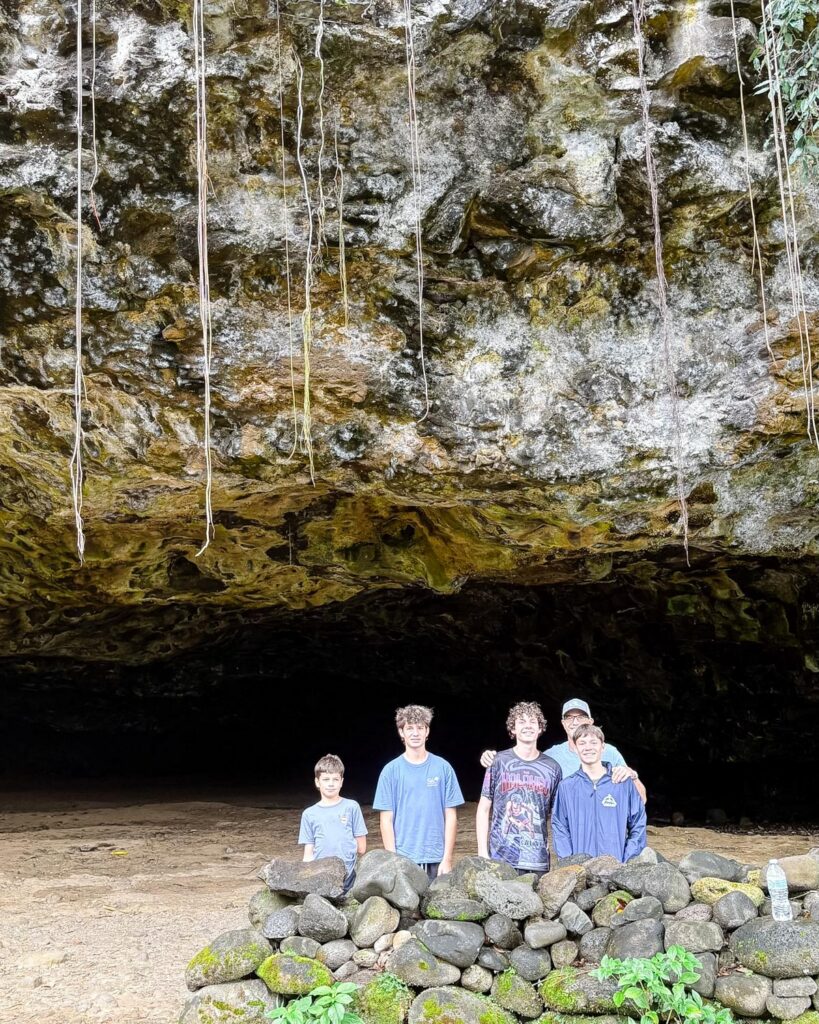 Family exploring a cave on the North Shore during Kauai family things to do in Kauaʻi, Hawaii. Family photos by Alison Bell, photographer in Hawaii.