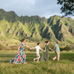 Family walking at Koสปolau Mountains in Oahu, Hawaii. Kualoa Regional Park photos by Alison Bell, photographer.