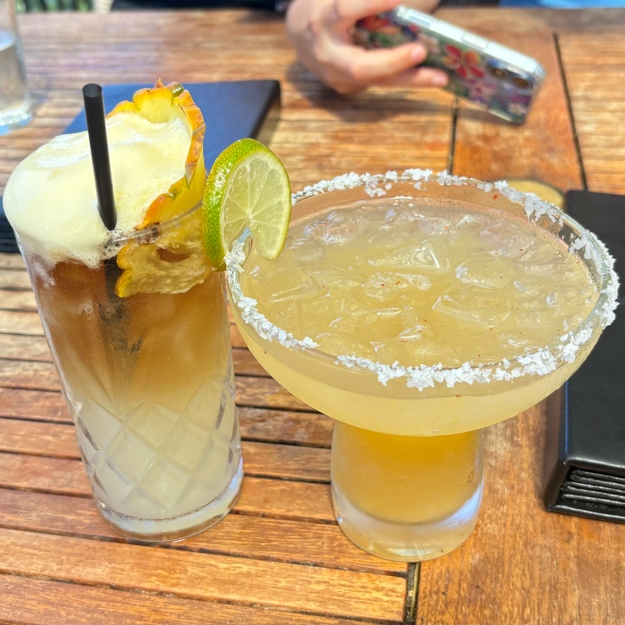 Two tropical cocktails with pineapple and lime garnishes at Kahuku Beer Garden on Oahu. Photography by Alison Bell, photographer in Hawaii.